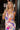 Front view of model wearing the Isla Multi Swirl Midi Dress which features purple, fuchsia, peach, yellow, green, light pink and white knit fabric, wattercolor swirl print, peach lining, mid length, v-neckline, thick straps and sleeveless.