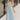 Full body view of model wearing the Gillie Light Blue Halter Maxi Dress which features light blue and yellow knit textured fabric, light blue lining, small gingham print design, maxi length, halter neckline, adjustable straps, sleeveless and open back.