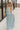 Full body view of model wearing the Gillie Light Blue Halter Maxi Dress which features light blue and yellow knit textured fabric, light blue lining, small gingham print design, maxi length, halter neckline, adjustable straps, sleeveless and open back.
