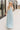 Full body view of model wearing the Gillie Light Blue Halter Maxi Dress which features light blue and yellow knit textured fabric, light blue lining, small gingham print design, maxi length, halter neckline, adjustable straps, sleeveless and open back.