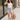 Full body front view of female brunette model wearing the light wash color of the Hayden Frayed Hem Denim Shorts, paired with a white tank top.