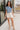 Full body view of model wearing the Carmen Blue & Cream Floral Top which features blue and cream knit fabric, floral pattern, round neckline, ruffle short sleeves and keyhole back with button closure.