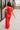 Full body back view of model wearing the Vada Red Tank Top that features red woven fabric with raw frayed hems, a round neckline, a sleeveless body, small side slits, and a keyhole back with a button closure.