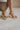 Ariel view of female model wearing the Chinese Laundry Theresa Platform Heel in Metallic which features gold metallic faux leather fabric, block heel, round toe, platform sole and adjustable strap.