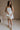 Full body view of female model wearing the Kate Off White Floral Strapless Mini Dress which features White Floral Print, Tiered Body, Mini Length, White Lining Sweetheart Neckline, Strapless and Back Zipper with Hook Closure.