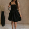 Full body view of female model wearing the Abigail Strapless Flare Mini Dress in black which features features Mini Length, Lining, Two Side Pockets, Strapless and Monochrome Back Zipper with Hook Closure.