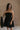 Front view of female model wearing the Abigail Strapless Flare Mini Dress in black which features features Mini Length, Lining, Two Side Pockets, Strapless and Monochrome Back Zipper with Hook Closure.