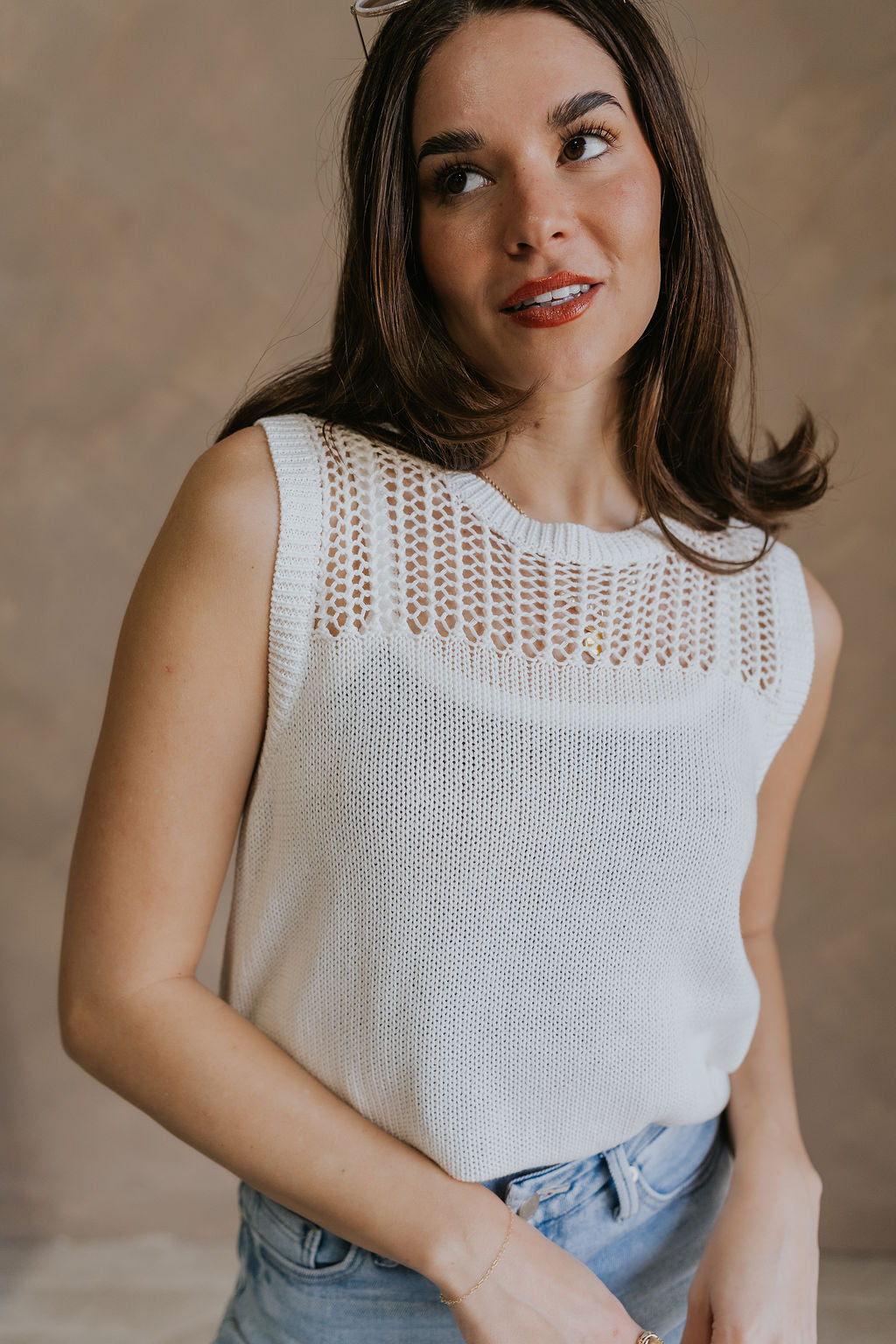 Close up view of female model wearing the Elisa Cream Knit Sleeveless Tank which features Cream Cotton Fabric, Open Knit Details, Round Neckline and Sleeveless