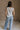 Full body back view of female model wearing the Elisa Cream Knit Sleeveless Tank which features Cream Cotton Fabric, Open Knit Details, Round Neckline and Sleeveless