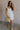 Full body view of female model wearing the Melissa Off White Floral Ruffle Straps Dress which features White Floral Print, Tiered Body, Mini Length, White Lining, Sweetheart Neckline and Ruffle Straps.