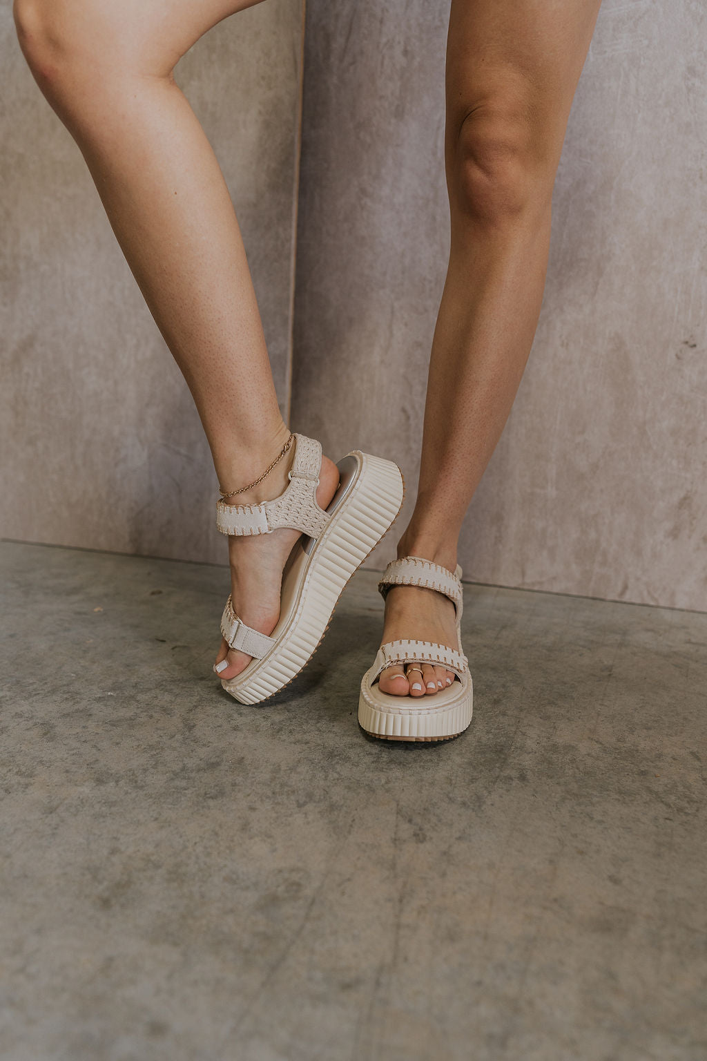 Front view of female model wearing the Debra Sandal in Ivory Suede which features ivory suede and white rattan fabric, white platform sole, rubber outsole and adjustable velcro straps