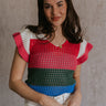 Front view of female model wearing the Andrea Pink Multi Knit Ruffle Top which features Blue, Green, Pink, Grey and Cream Open Knit Fabric, Ruffle Hem, V-Neckline and Short Sleeves