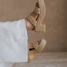 Right side view of female model wearing the Ocean Ave Platform Sandal in Tan which features Tan Braided Raffia Fabric, 1.5 inch platform sole, 3 inch block heel, Slip-On Style, Round Toe and Padded Insole