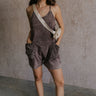 Full body view of female model wearing the Vera Washed Black Sleeveless Romper which features Washed Black Cotton Fabric, Two Side Pockets , V-Neckline, Sleeveless and Adjustable Straps
