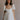 Front view of female model wearing the Julia Off White Short Puff Sleeve Mini Dress which features Off White Stripe Sheer Fabric, White Lining, Mini Length, Ruched Upper, Sweetheart Neckline, Short Puff Sleeves and Back Cut-Out Detail with Zipper and Tie Closure
