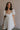 Front view of female model wearing the Julia Off White Short Puff Sleeve Mini Dress which features Off White Stripe Sheer Fabric, White Lining, Mini Length, Ruched Upper, Sweetheart Neckline, Short Puff Sleeves and Back Cut-Out Detail with Zipper and Tie Closure
