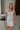 Front view of female model wearing the Emerson White Blue Floral Ruffle Mini Dress which features White Lightweight Fabric, Blue Floral Print, Ruffle Hem Design, Square Neckline and sleeveless