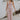 Full body view of female model wearing the Aleah Mauve Pink Sleeveless Jumpsuit which features Mauve Pink Lightweight Fabric, Wide Leg Pants, Upper Ruched Detail, Two Side Pockets, Scooped Neckline, Adjustable Straps and Open Back with Tie Closure and Zipper