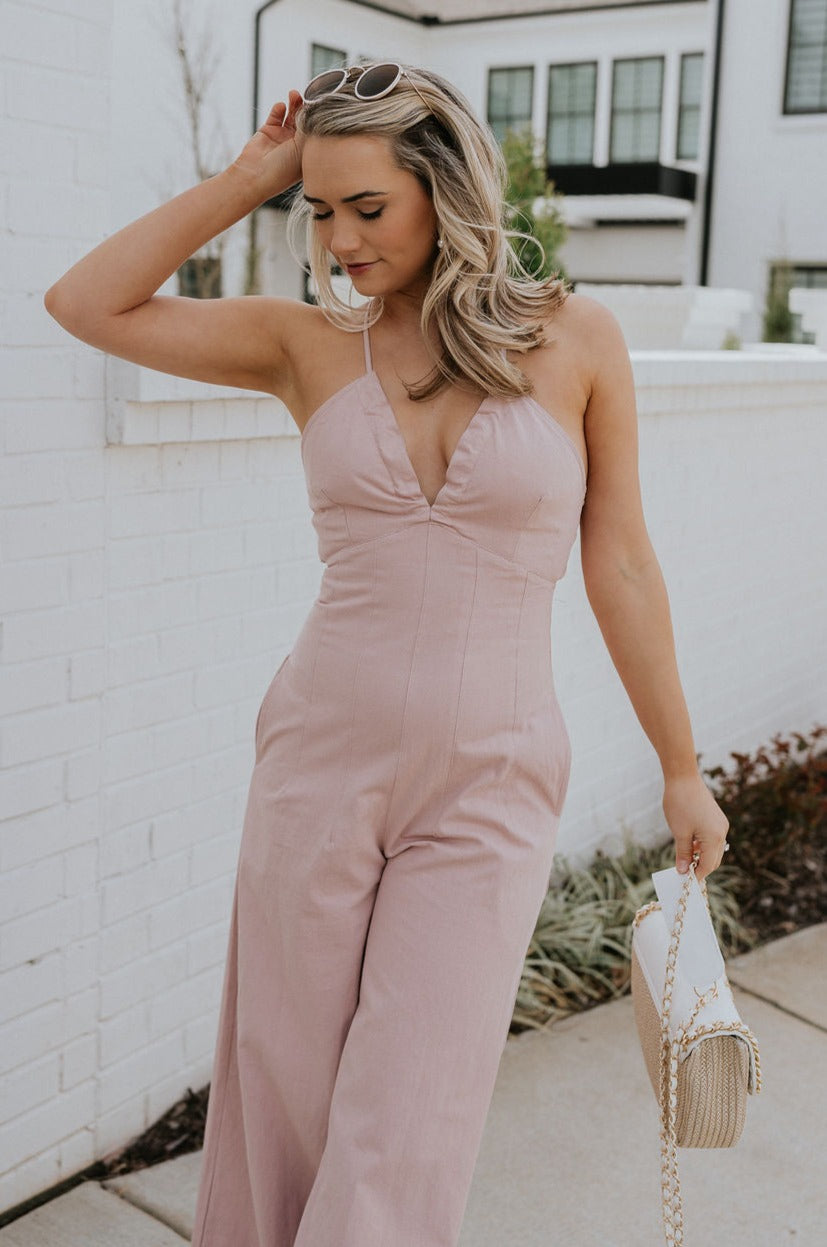 Front view of female model wearing the Aleah Mauve Pink Sleeveless Jumpsuit which features Mauve Pink Lightweight Fabric, Wide Leg Pants, Upper Ruched Detail, Two Side Pockets, Scooped Neckline, Adjustable Straps and Open Back with Tie Closure and Zipper