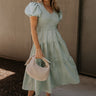 Full body view of female model wearing the Sloan Sage Puff Sleeve Midi Dress which features Light Sage Lightweight Fabric, Light Sage Lining, Midi Length, Tiered Skirt, Smocked Upper, V-Neckline and Short Puff Sleeves