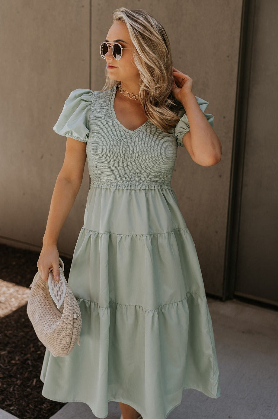 Front view of female model wearing the Sloan Sage Puff Sleeve Midi Dress which features Light Sage Lightweight Fabric, Light Sage Lining, Midi Length, Tiered Skirt, Smocked Upper, V-Neckline and Short Puff Sleeves