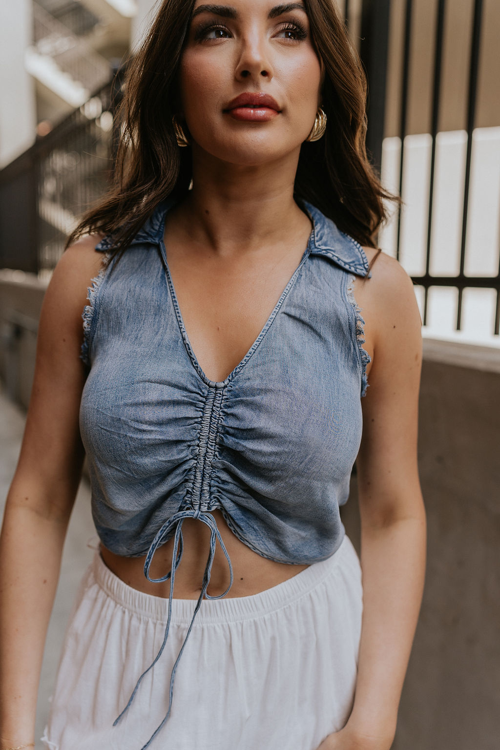Clos eup view of female model wearing the Dallas Denim Ruched Tank Medium Denim Lightweight Fabric, Front Ruched Detail, Scoop Neckline, Collared Neckline and Sleeveless