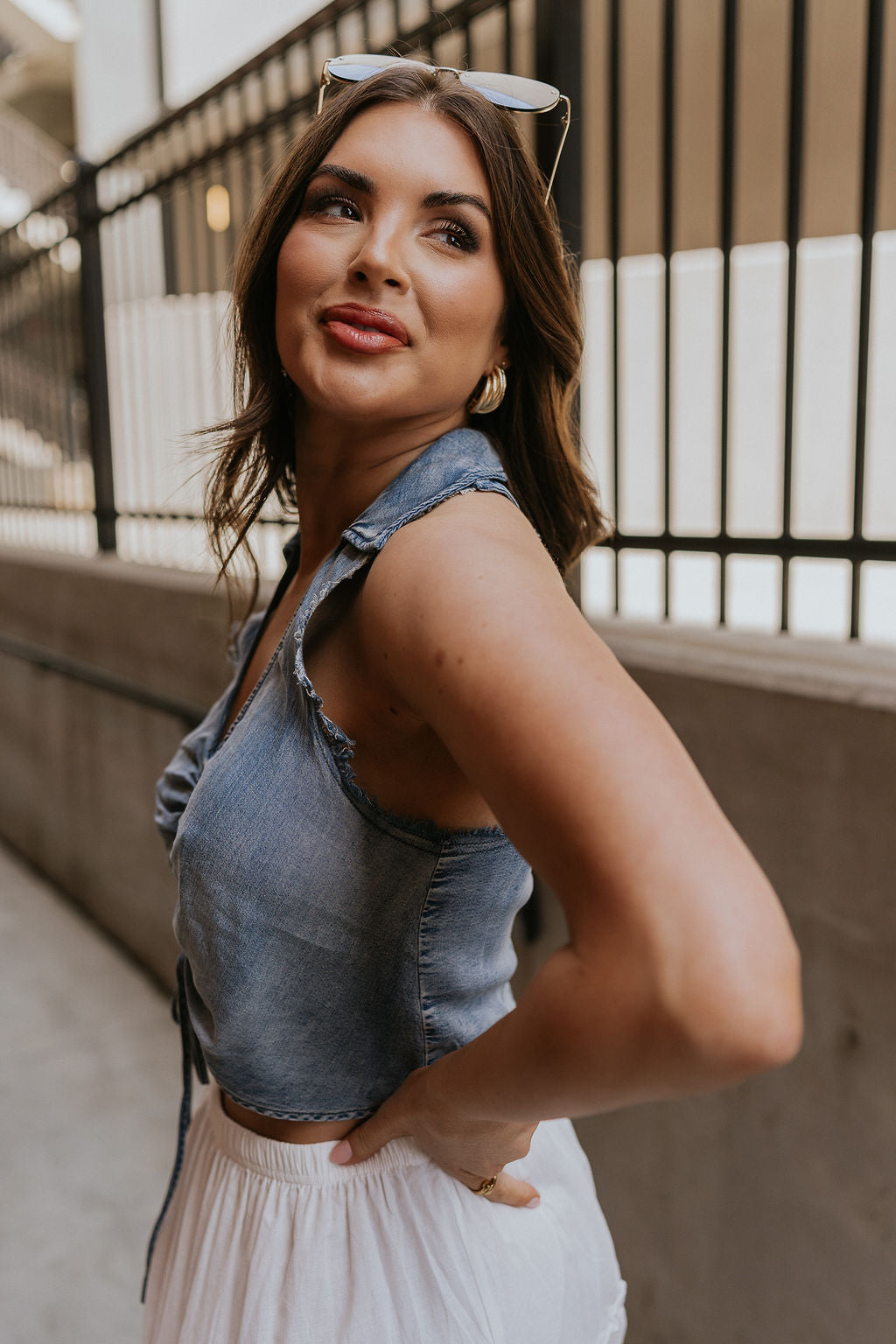 Side view of female model wearing the Dallas Denim Ruched Tank Medium Denim Lightweight Fabric, Front Ruched Detail, Scoop Neckline, Collared Neckline and Sleeveless