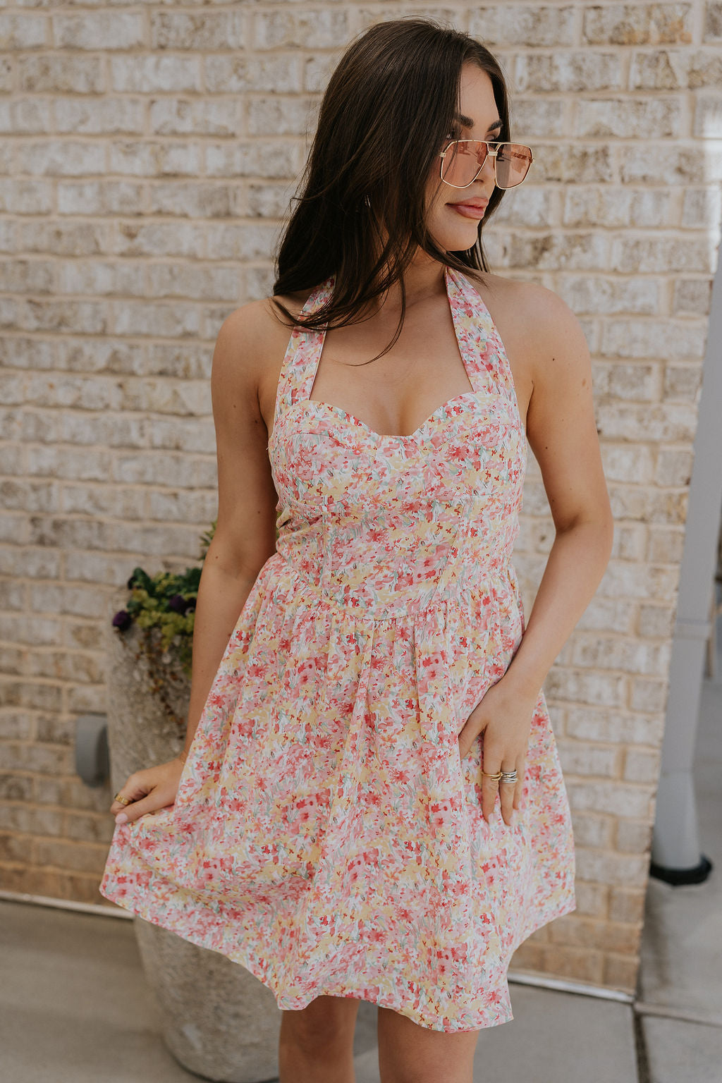 Front view of female model wearing the Sara Pink Floral Halter Mini Dress which features Pink Multi Floral Pattern, Mini Length, Corset Upper Detail, Sweetheart Neckline and Halter Neckline with Tie closure