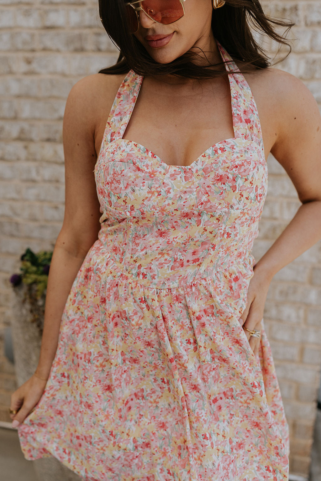 Close up view of female model wearing the Sara Pink Floral Halter Mini Dress which features Pink Multi Floral Pattern, Mini Length, Corset Upper Detail, Sweetheart Neckline and Halter Neckline with Tie closure