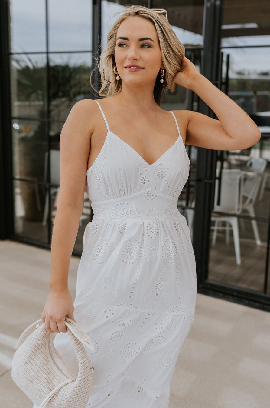 Front view of female model wearing the Morgan Off White Eyelet Maxi Dress which features White Lightweight Fabric, Eyelet Pattern, White Lining, Maxi Length, Tiered Body, Sweetheart Neckline, Adjustable Straps and Open Back with Bow Tie