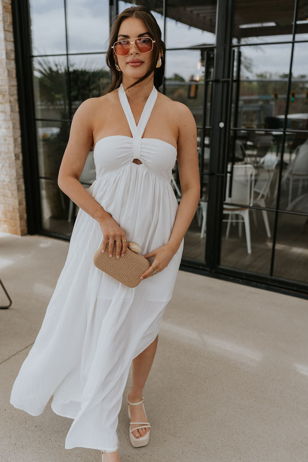 Full body view of female model wearing the Lina Off White Halter Neckline Maxi Dress which features White Lightweight Fabric, White Lining, Maxi Length, Slit Detail, Halter Tie Neckline with Key Hole Detail and Elastic Back