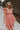 Front view of female model wearing the Allie Coral Pink Ruffle Midi Dress which features Coral Pink Lightweight Fabric, Midi Length, Coral Pink Lining, Ruffle Tier Skirt, Smocked Upper, Square Neckline, Ruffle Straps and Two Side Pockets