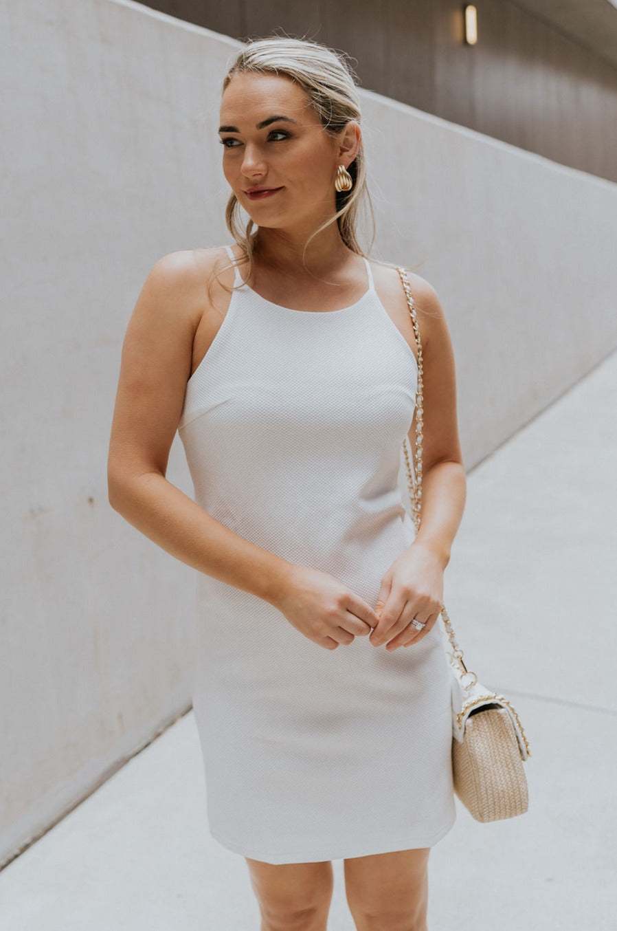 Front view of female model wearing the Nadia Off White Halter Neckline Mini Dress which features White Textured Fabric, Mini Length, White Lining, Halter Neckline and Monochrome Back Zipper with Hook Closure