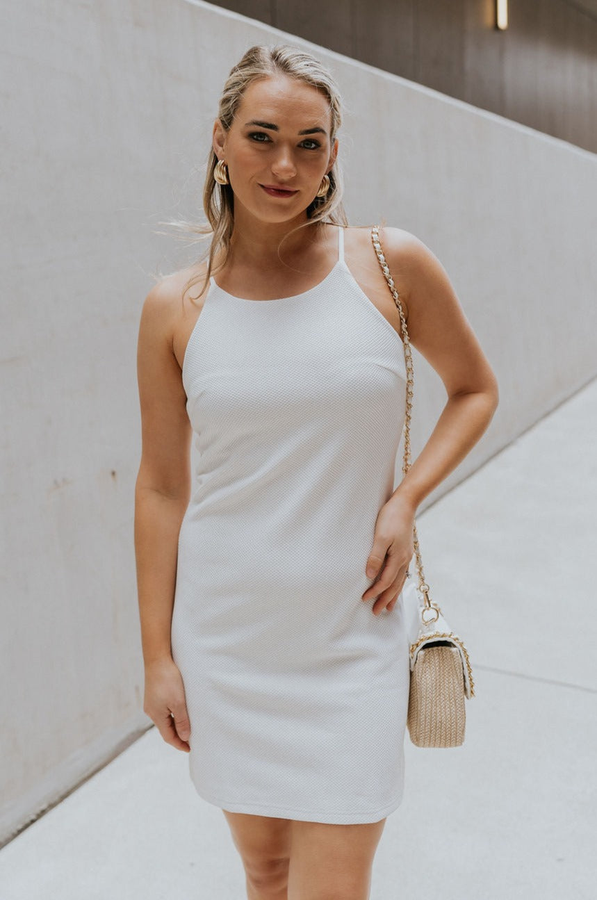 Front view of female model wearing the Nadia Off White Halter Neckline Mini Dress which features White Textured Fabric, Mini Length, White Lining, Halter Neckline and Monochrome Back Zipper with Hook Closure