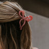 Back view of female model's hair; model is wearing the Zoey Bow Claw Clip in Pink.