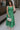 Full body view of female model wearing the Selah Green Smocked Midi Dress which features Green Lightweight Fabric, Ruffle Tiered Body, Green Lining, Midi Length, Smocked Upper, Square Neckline and Thick Straps