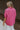 Back view of female model wearing the Everlee Pink Short Sleeve Top which features Pink Lightweight Fabric, Short Sleeves with Pearlescent Buttoned Cuffs and Collar Neckline with V-Cutout