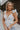 Front view of female model wearing the Lauren White Ruffle Plunge Neckline Tank which features White Lightweight Fabric, Peplum Hem Body, Sweetheart Neckline, Ruffle Straps, Open Back Corset Tie and Back Zipper with Hook Closure