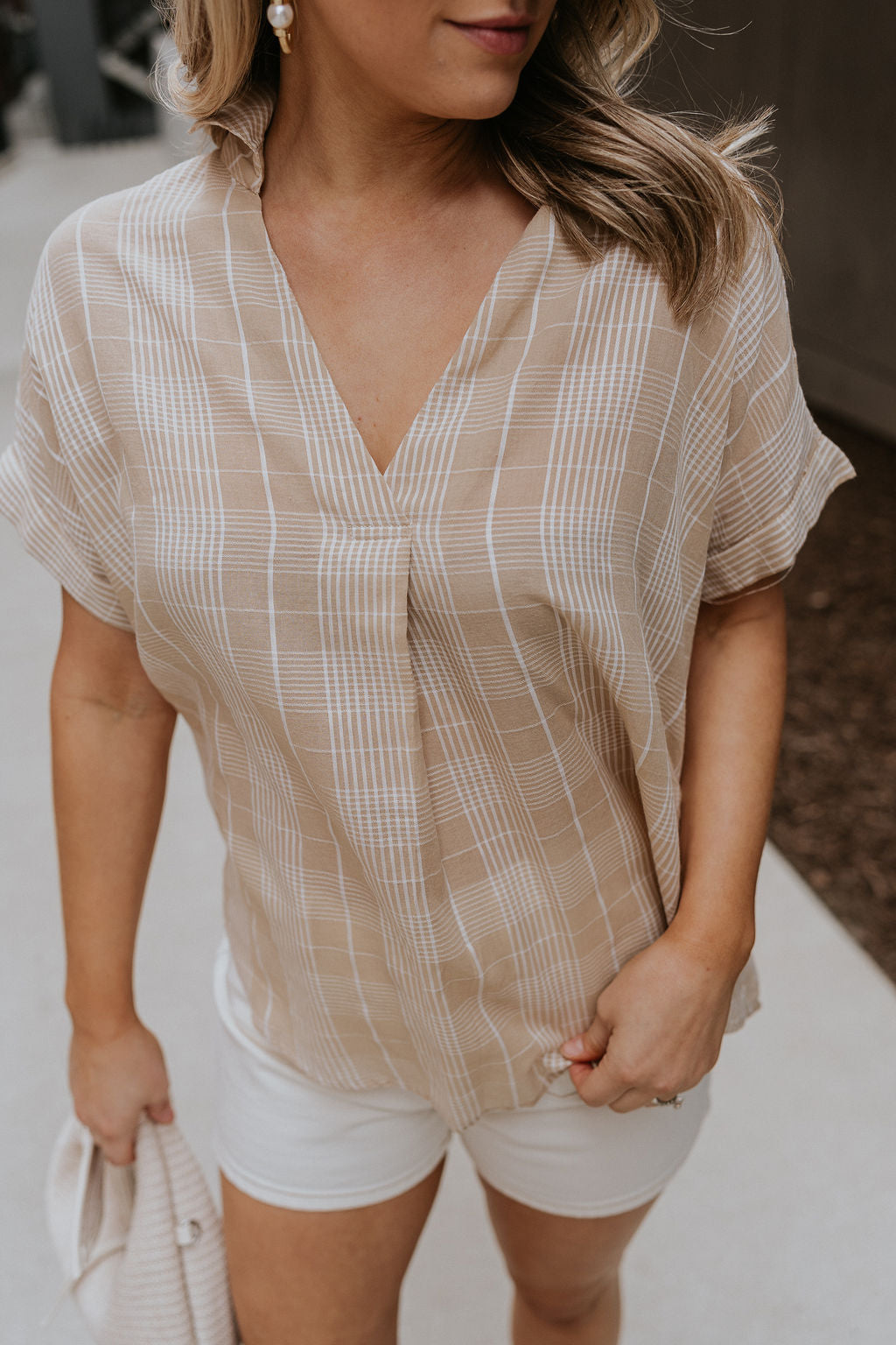 Close up view of female model wearing the Kali Light Beige Plaid Short Sleeve Top which features Taupe and White Cotton Fabric, Plaid Print, Short Sleeves and V-Neckline with Collar