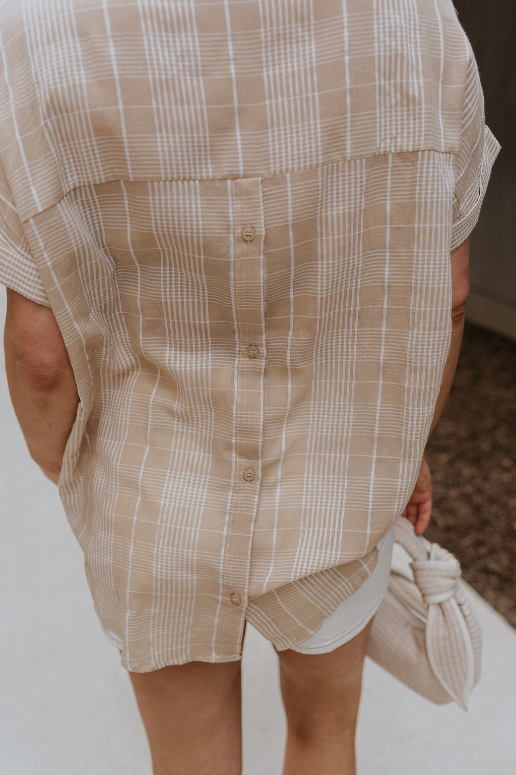 Close up view of female model wearing the Kali Light Beige Plaid Short Sleeve Top which features Taupe and White Cotton Fabric, Plaid Print, Short Sleeves and V-Neckline with Collar