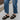 Side view of female model wearing the ONA Streetworks Slide Flat Sandal in Black & Chalk which features Black Light Foam Leather Upper, Two Straps, Slide-On Style, High-Traction Rubber Platform Sole and 2" Heel Height, 1 1/2" Platform Height