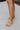 Frontal side view of female model wearing the ONA Streetworks Go-To Flat Sandal in Honest Beige & Sea Salt which features Beige Leather Upper, Adjustable Buckle Closure with Back Strap, White Molded Rubber Sole and 1" Platform Height