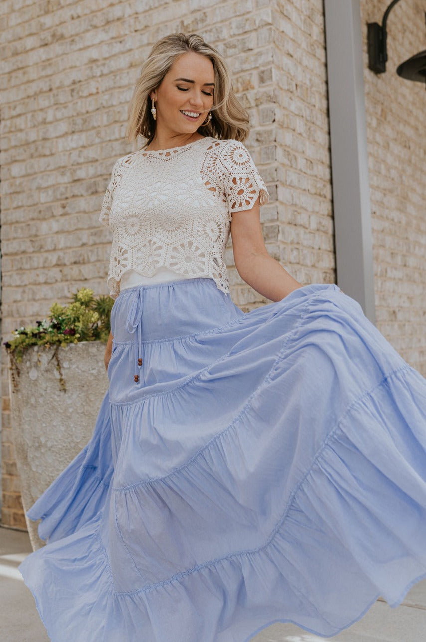 Full body view of female model wearing the Alana Periwinkle Tiered Maxi Skirt which features Periwinkle Lightweight Fabric, Maxi Length, Periwinkle Thigh Length Lining, Tiered Body and Elastic Waistband with Drawstring Ties