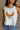 Close up view of female model wearing the Free Bird Smoke Cropped Tank which features Cream Cotton Fabric, Cropped Lettuce Hem, Round Neckline, Sleeveless and Eagle Graphic