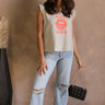 Full body view of female model wearing the Kiss Stone Taupe Graphic Top which features Stone Taupe Cotton Fabric, Distressed Details, Sleeveless, Round Neckline and Kiss Graphic with Lips