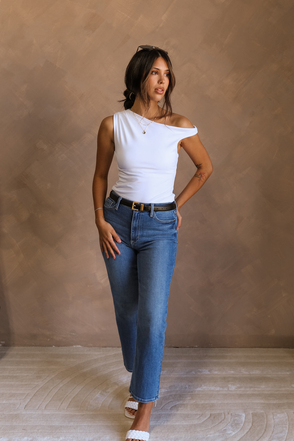 Full body front view of model wearing the Oakley White Sleeveless Top which features light blue knit fabic, cropped waist, scooped neckline, thick straps and sleeveless.