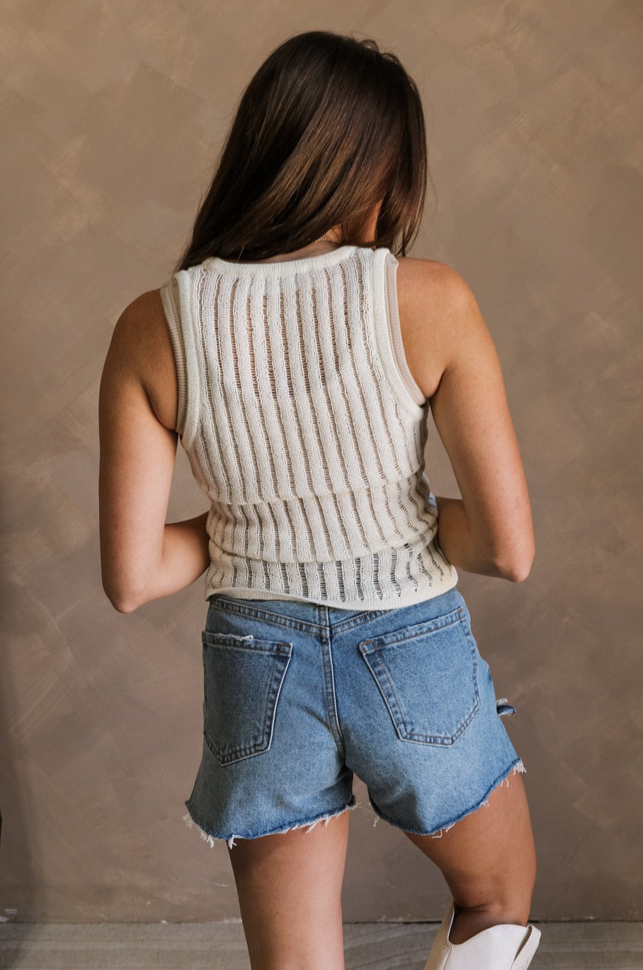 Back view of female model wearing the Bria Cream Knit Sleeveless Tank which features Cream Knit Fabric, Round Neckline and Sleeveless