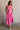 Full body view of female model wearing the Valery Pink Tiered Midi Skirt which features Pink Cotton Fabric, Pink Lining, Upper Pleated Details and Smocked Waistband
