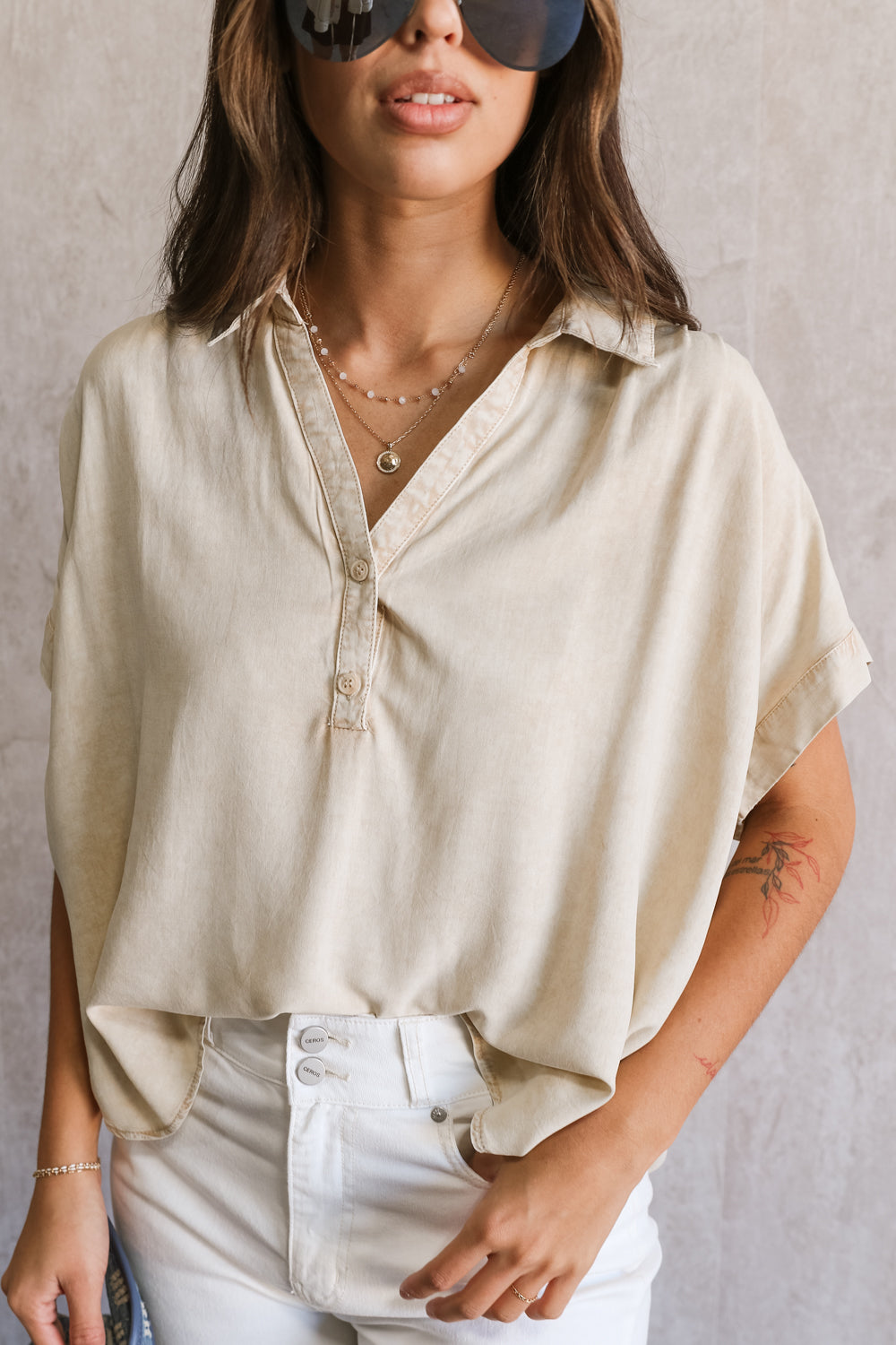 front view of female model wearing the Amalia Collared Short Sleeve Top in taupe, which has short sleeves and a collar neckline.Top is front tucked