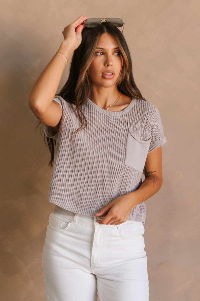 Front view of female model wearing the Harper Grey Knit Short Sleeve Top which features Grey Small Cable Knit Fabric, Left Front Chest Pocket, Round Neckline and Short Sleeves